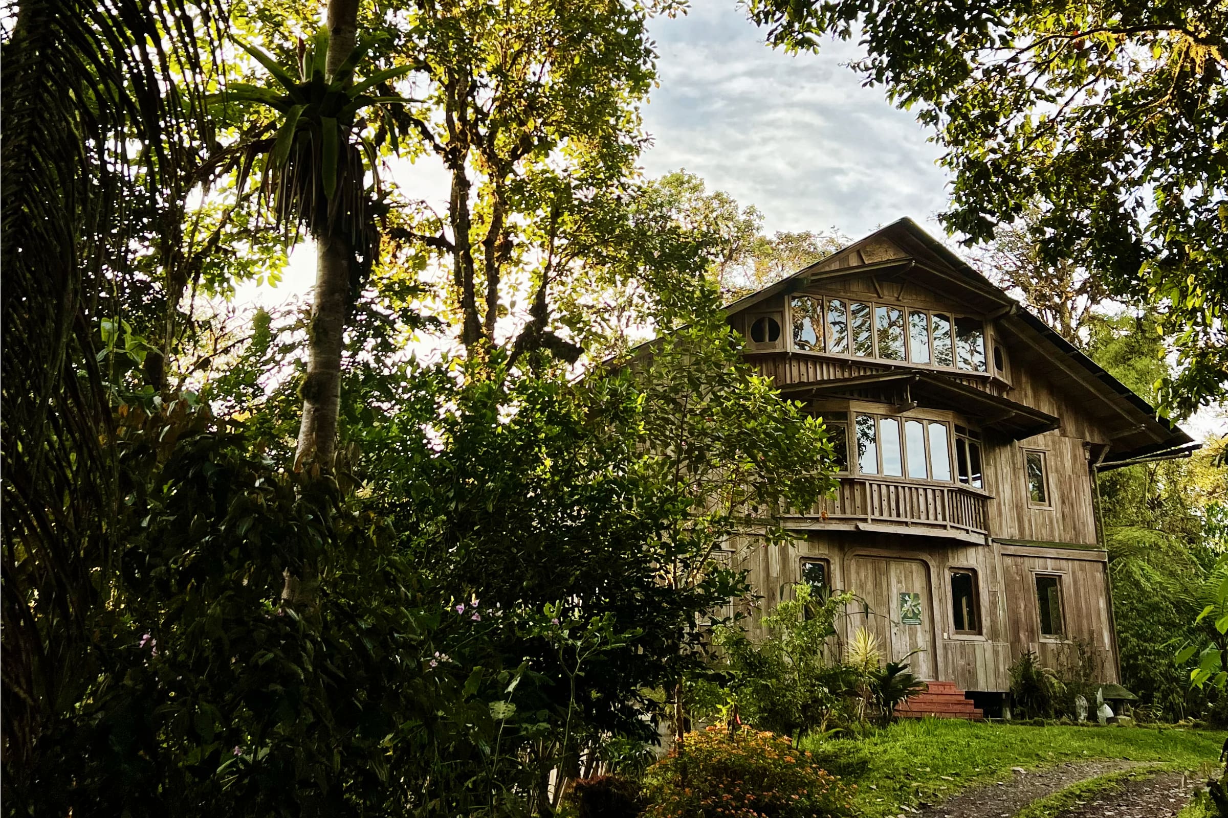 The Mindo Lindo Environmental Center is a three story wooden building surrounded by gardens and trees
