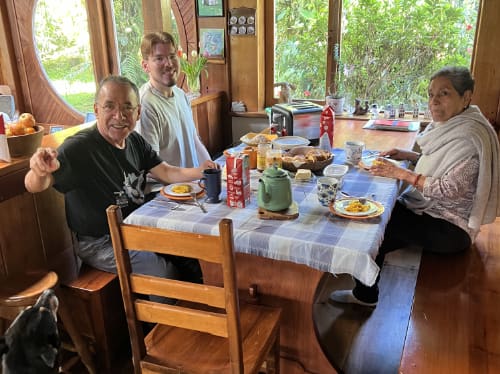 Three people enjoying breakfast at an indoor dining room table